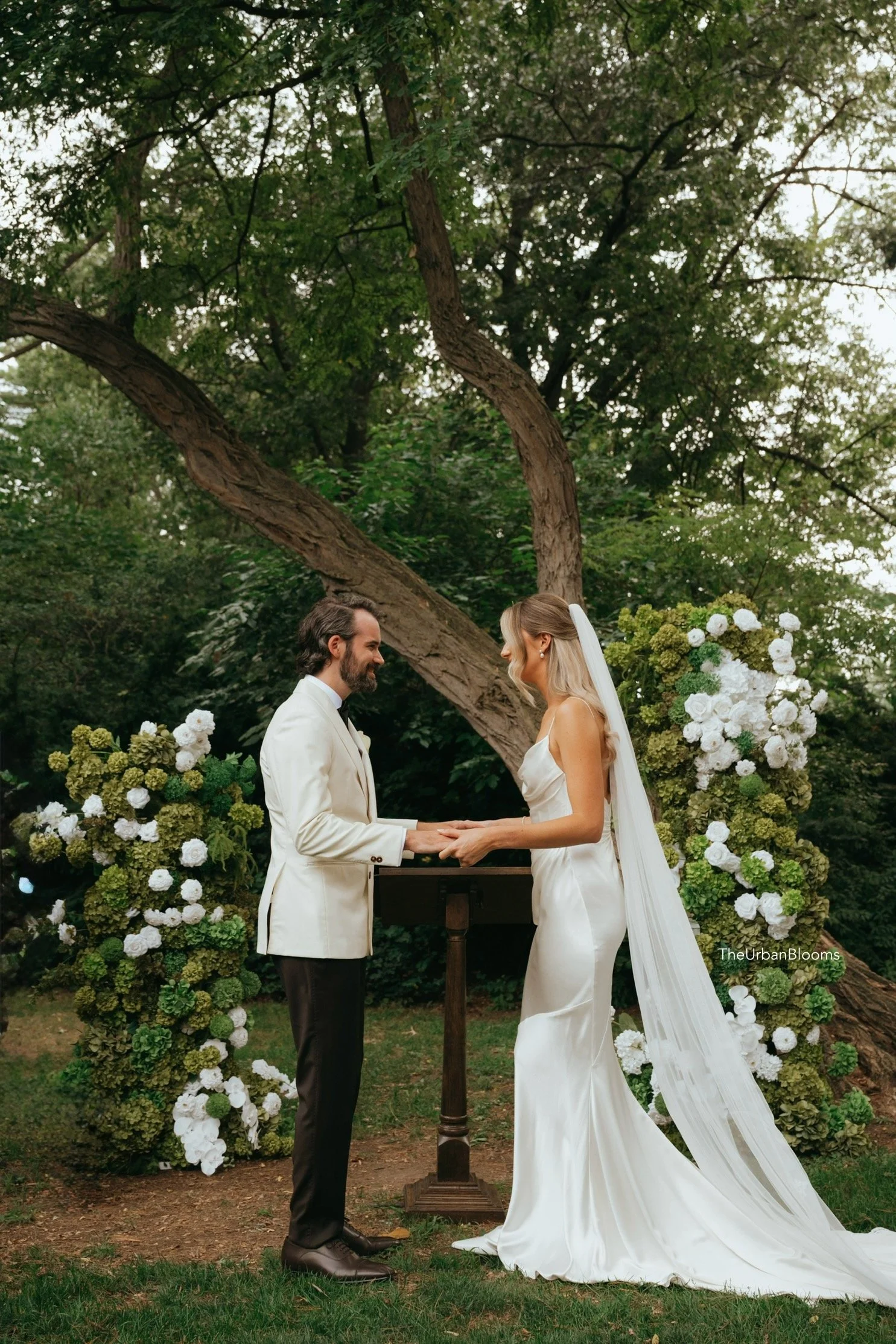 Lush faux green garden arch with white florals